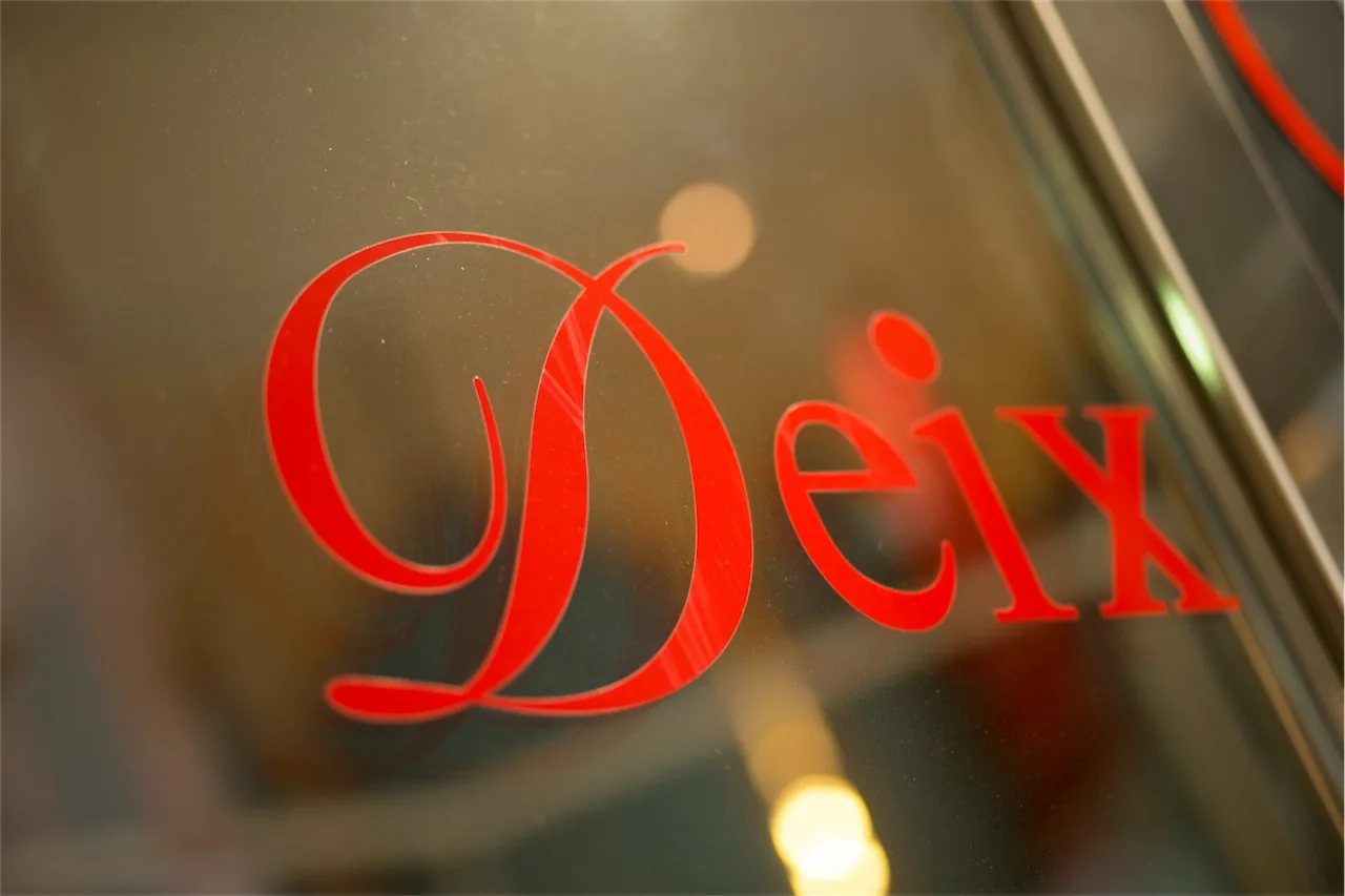 Roter Schriftzug „Deix“ auf der Glastür der Herz Jesu-Apotheke